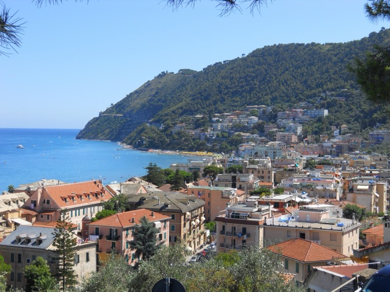 Capo Mele visto dall'alto di Laigueglia, promontorio verde sul mare con le case del paese