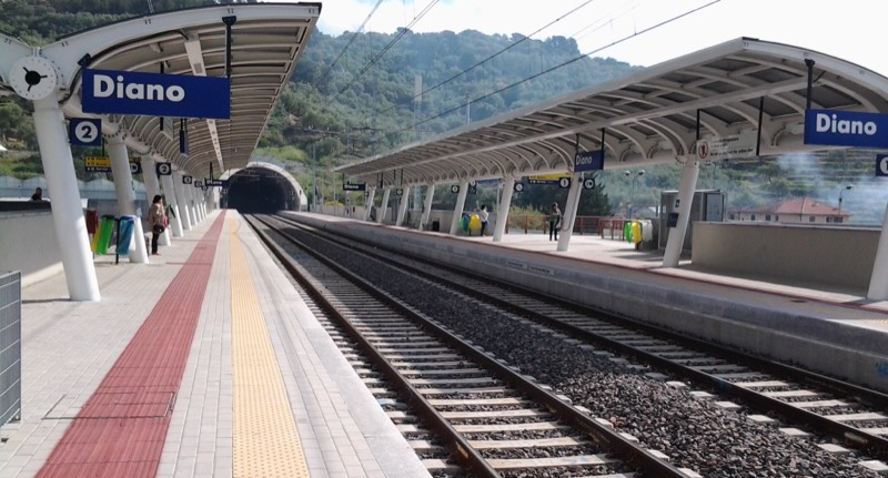Banchine e binari della stazione ferroviaria di Diano con pensiline e imbocco della galleria