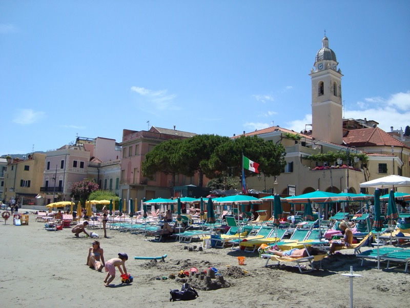 Bambini che giocano con la sabbia sulla spiaggia di Alassio, tra ombrelloni e castelli di sabbia
